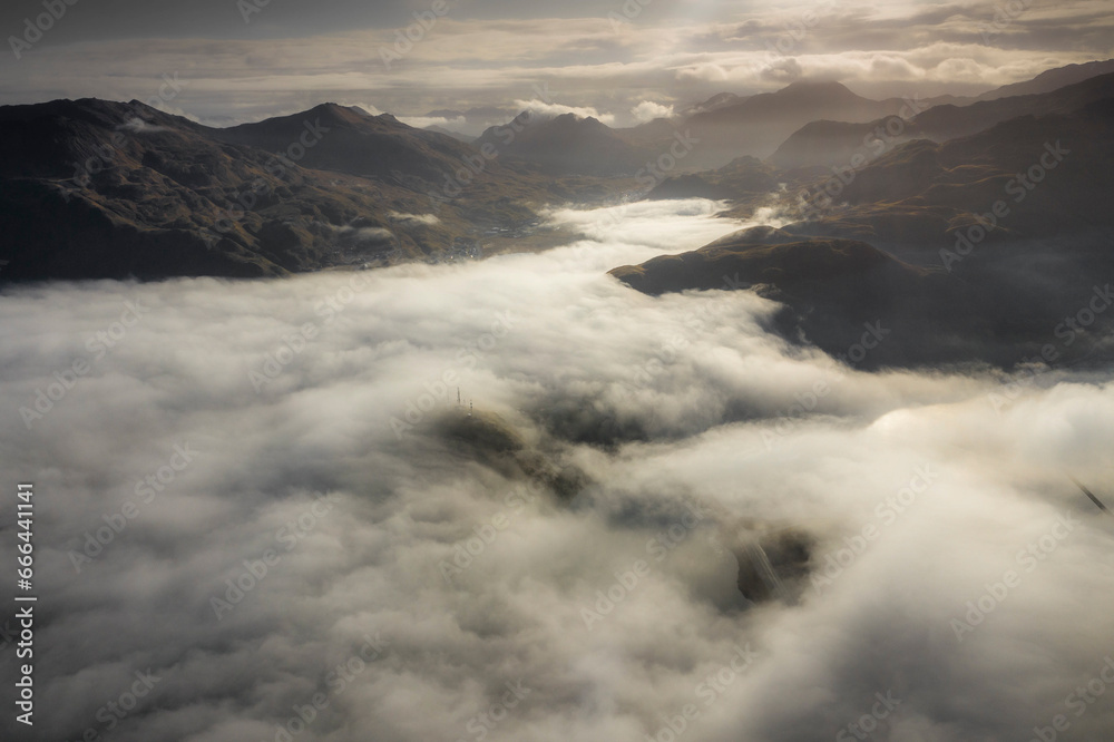 View of a mountain landscape with low clouds as fog in Dutch harbour, Unalaska island, Alaska, United States. View of a mountain landscape with low clouds as fog in Dutch harbour, Unalaska island, Alaska, United States.