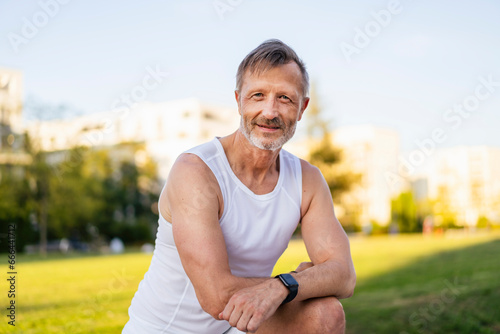 Smiling mature athlete standing in park