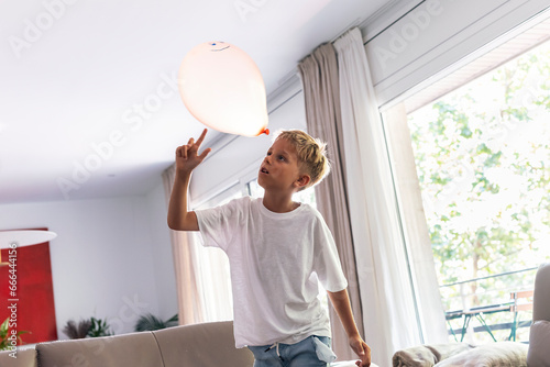 Boy playing with balloon at home photo