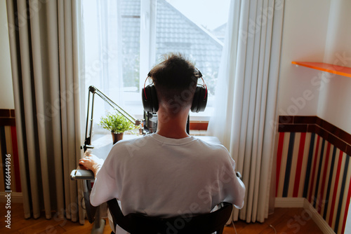 Teenage boy podcasting with microphone at home photo