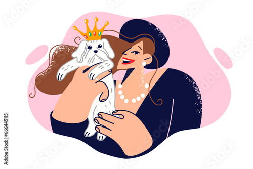 Woman holds small dog with crown on head and smiles, dressed in glamorous clothes for party