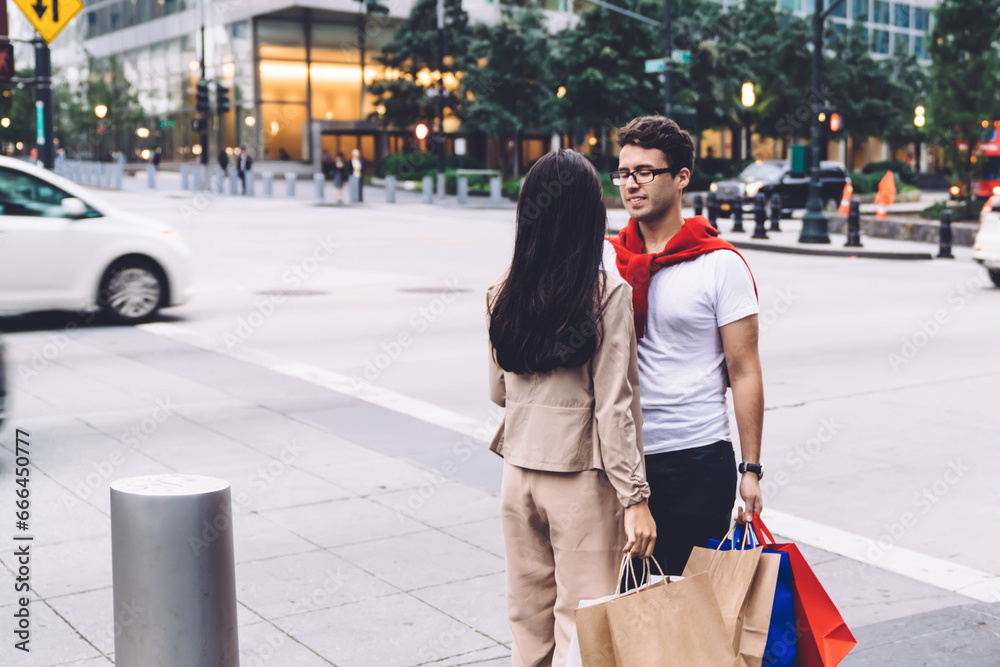 Loving couple with shopping bags standing at crossroad
