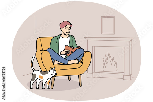 Happy young man sit in chair at home near fireplace reading book. Smiling guy relax in armchair enjoying literature. Hygge and domestic weekend. Vector illustration.