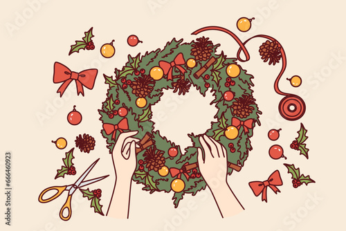 Diy christmas wreath made from green fir branches and red bows or pine cones for interior decoration. Process of making christmas wine to prepare for new year holidays or xmas eve.