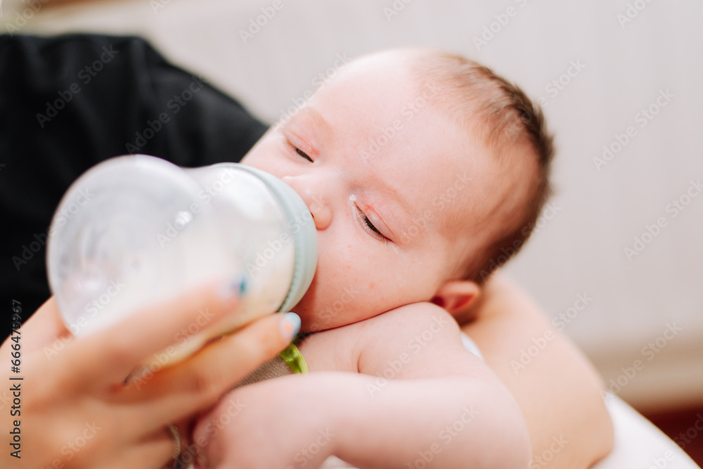 portrait of a newborn drinking from a feeding bottle portrait of a newborn drinking from a feeding bottle