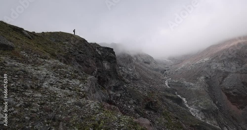 Woman alone hiking on trek path in Cacasus mountains towards Gergeti glaciar Stepantsminda photo