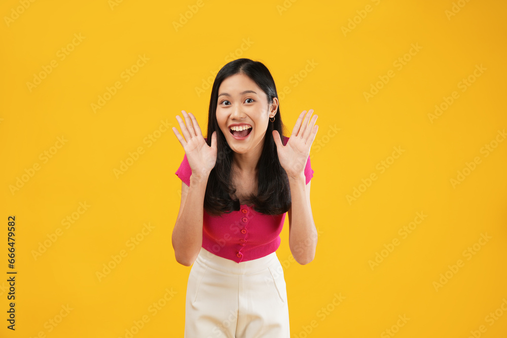 Photo of a surprised young Asian woman looking excited holding her mouth open, hands on head. Photo of a surprised young Asian woman looking excited holding her mouth open, hands on head.