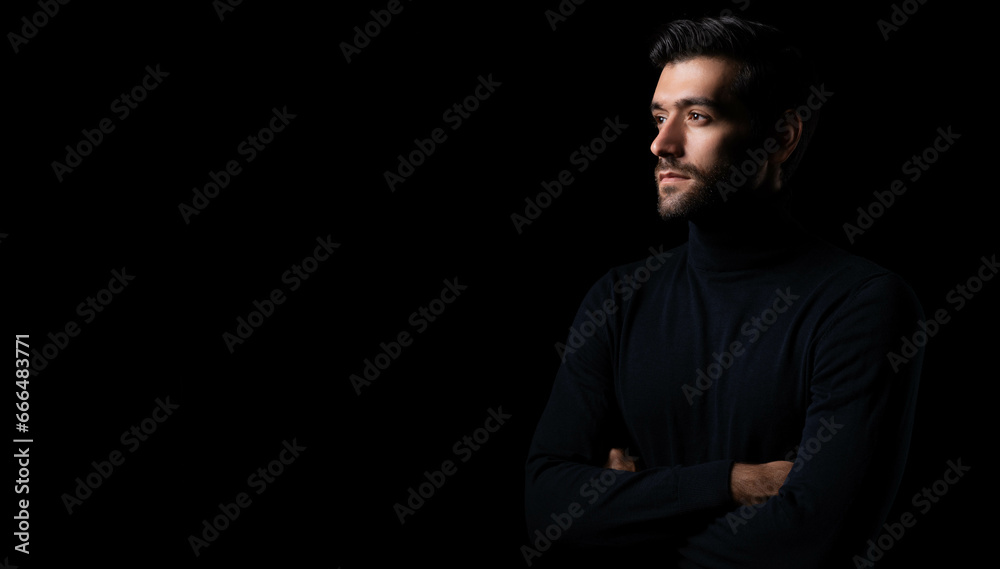 Confidence handsome young man with folded arms Attractive businessman look at copy space with crossed arms studio shot standing in the dark room black background Successful young guy portrait