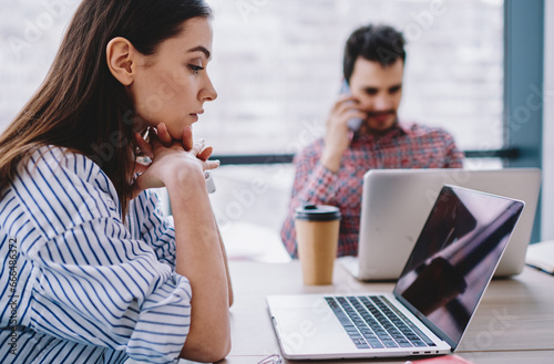 serious female entrepreneur watching video via application on netbook for browsing internet