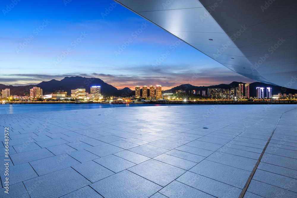 Empty square floor and city skyline with modern buildings at night