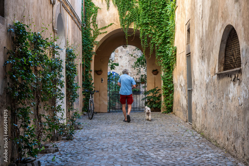 Uomo passeggia con il cane in un vicolo di un borgo medievale © Emiliano Albensi