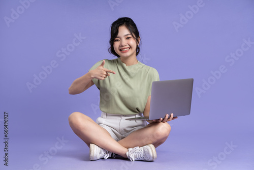 Portrait of beautiful asian woman posing on purple background © 1112000