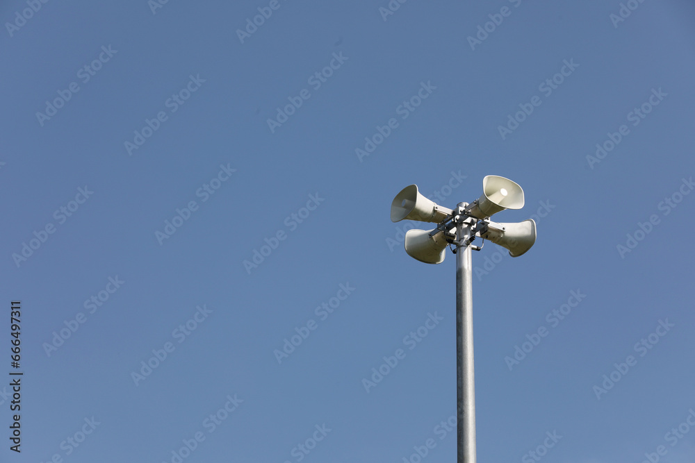 Whire horn speaker in the park with clear blue sky background.. Whire horn speaker in the park with clear blue sky background..
