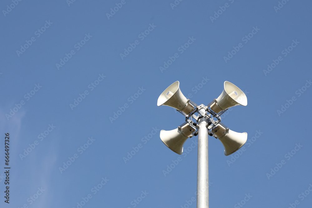 Whire horn speaker in the park with clear blue sky background.. Whire horn speaker in the park with clear blue sky background..