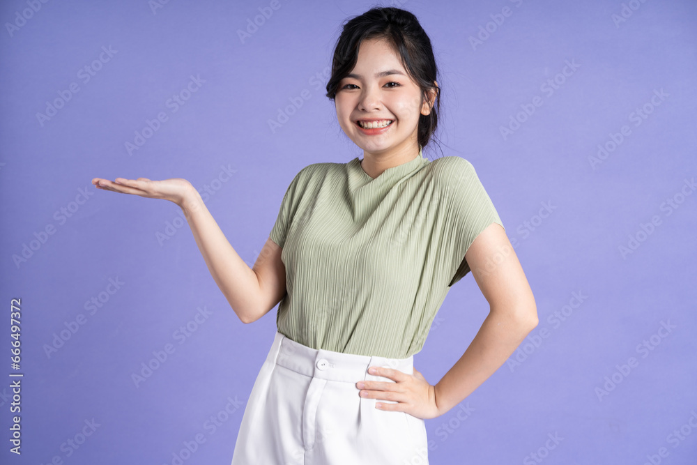 Portrait of beautiful Asian girl posing on purple background Portrait of beautiful Asian girl posing on purple background