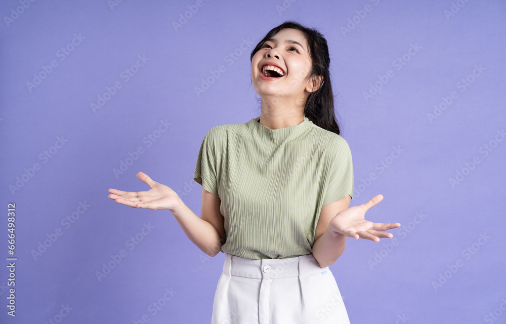 Portrait of beautiful Asian girl posing on purple background Portrait of beautiful Asian girl posing on purple background