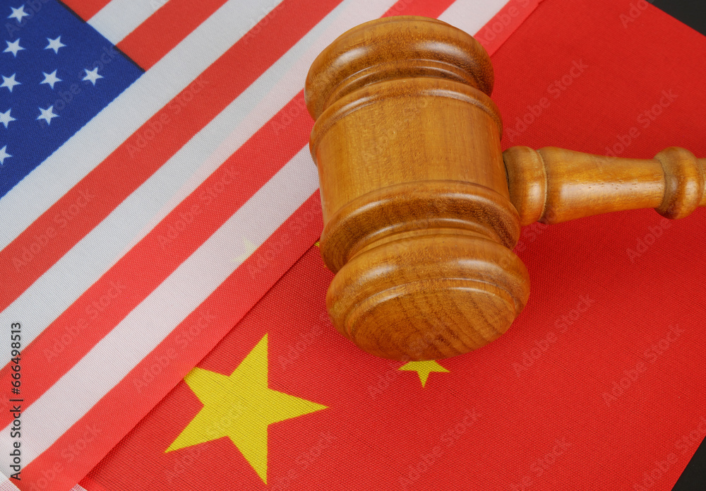 Economy conflict between China and US, tariffs on exports, trade frictions. Flags of USA and China with judge gavel close up.