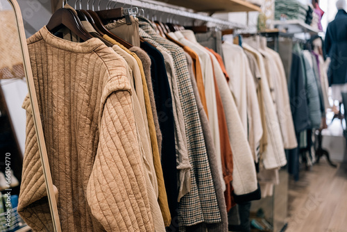 Variety of clothes displayed on hangers in a boutique.