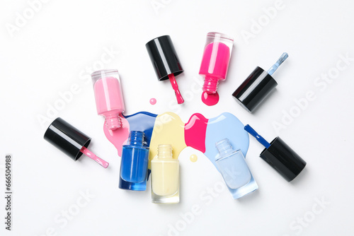 Multicolored open nail polishes on a white background