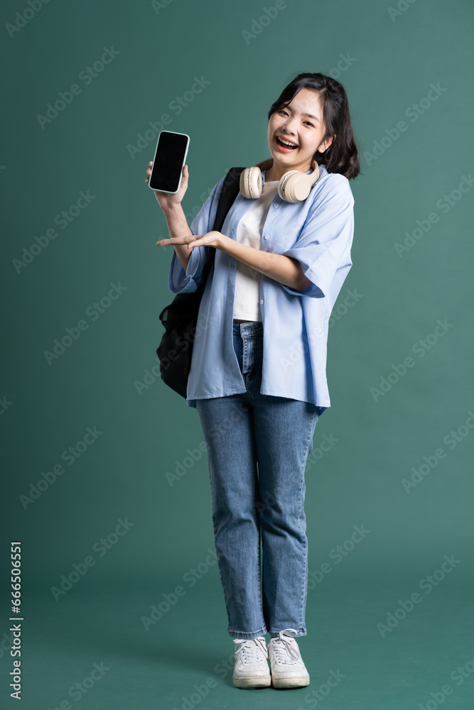 Portrait of a beautiful Asian student on a green background Portrait of a beautiful Asian student on a green background