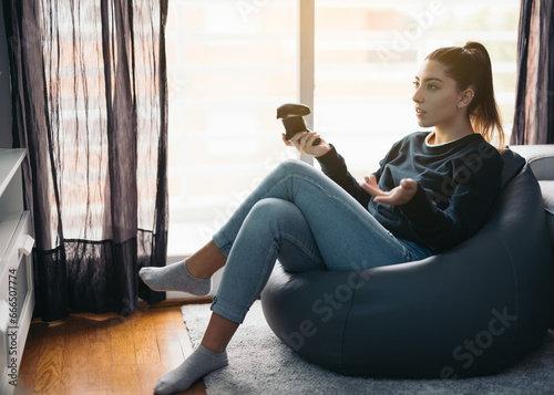 Serious woman with joystick losing the game at home photo