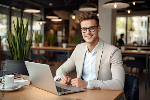 A modern, handsome businessman working on his laptop with expertise in a corporate office or a cafe.