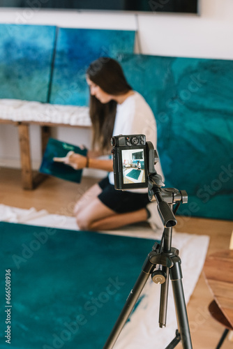 Professional female with painting shooting video on photo camera photo
