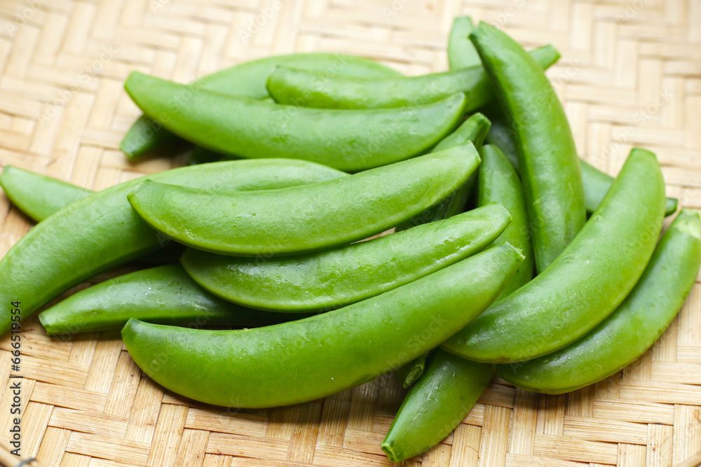 Fresh young green peas in bamboo weave plate