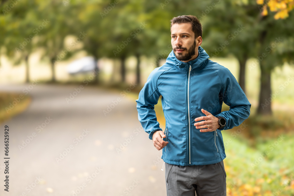 A young man is training and running in an autumn park. A young man is training and running in an autumn park.