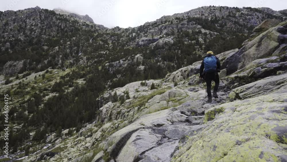 hiking high altitude mountains trekking path in Aigüestortes National Park solo male trekker carrying a backpack hiking high altitude mountains trekking path in Aigüestortes National Park solo male trekker carrying a backpack