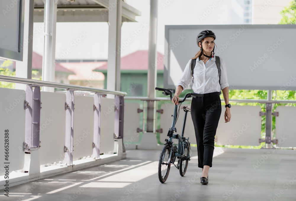 Eco friendly, businesswoman ride bicycle in urban to reduce carbon footprint. Beautiful woman environment conservation person commuting with bicycling. Cycling, alternative transport for green energy. Eco friendly, businesswoman ride bicycle in urban to reduce carbon footprint. Beautiful woman environment conservation person commuting with bicycling. Cycling, alternative transport for green energy.