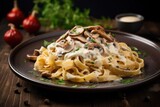 Italian fettuccine pasta with mushrooms and cream sauce served on a rustic wooden table
