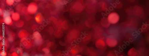 Blurred dark red sparkling background from sequins, macro. Shiny wine glittery bokeh of christmas garland.