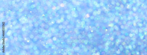 Blurred light blue sparkling background from sequins, macro. Shiny sky glittery bokeh of christmas garland.