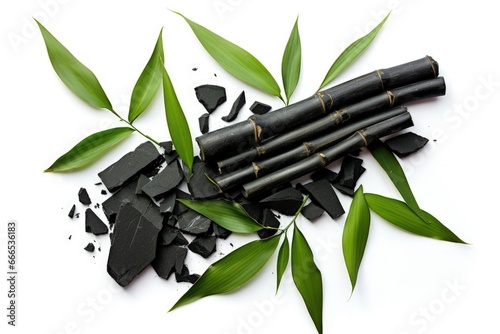 Top view of isolated activated charcoal with bamboo leaf on white background © VolumeThings