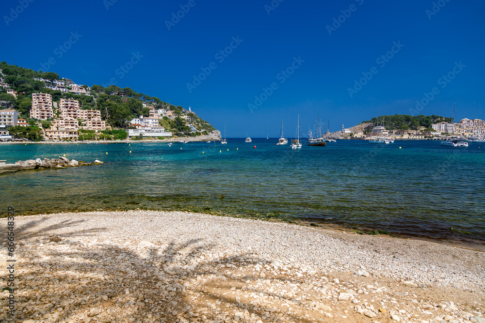 Beautiful view of Port de Soller beach with shade from palm trees, Mallorca