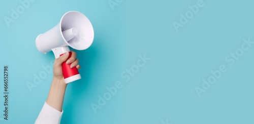 Hand Holding Megaphone on Vibrant Blue Background with Copy Space