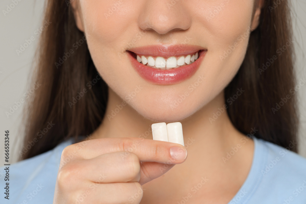 Woman with bubble gums on grey background, closeup Woman with bubble gums on grey background, closeup
