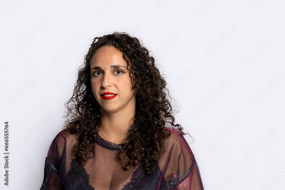 Young brunette woman with curly black hair wearing a sheer glitter t-shirt and black lingerie