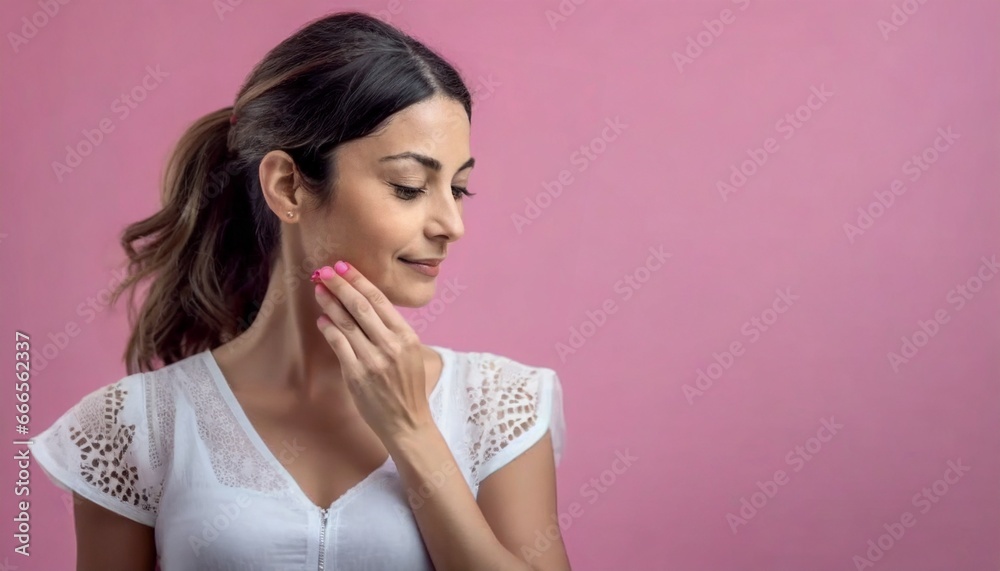 Fototapeta premium Mujer con fondo rosa tocándose la cara, cuidado de la piel, Retrato de mujer con piel suave y mano delicada tocando su rostro. Rostro hermoso y piel impecable, Hermosa piel natural. Cara de mujer.