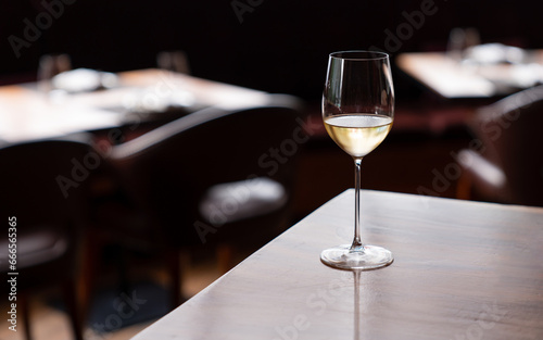 White wine in the wineglass on the table in restaurant.