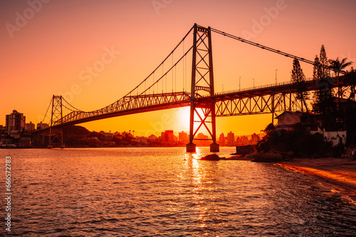 Hercilio luz bridge with warm sunset and bay waters in Florianopolis