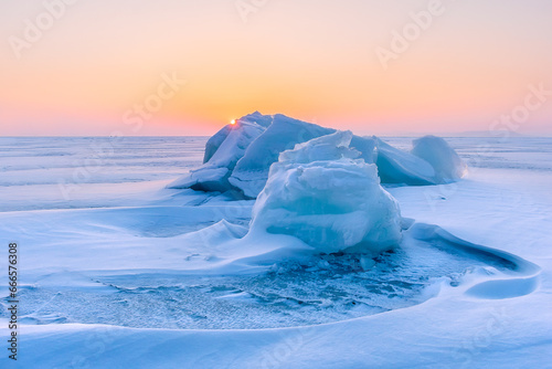 Blocks of ice on the surface of a frozen sea that is covered with snow. Frozen water surface with snow on it.