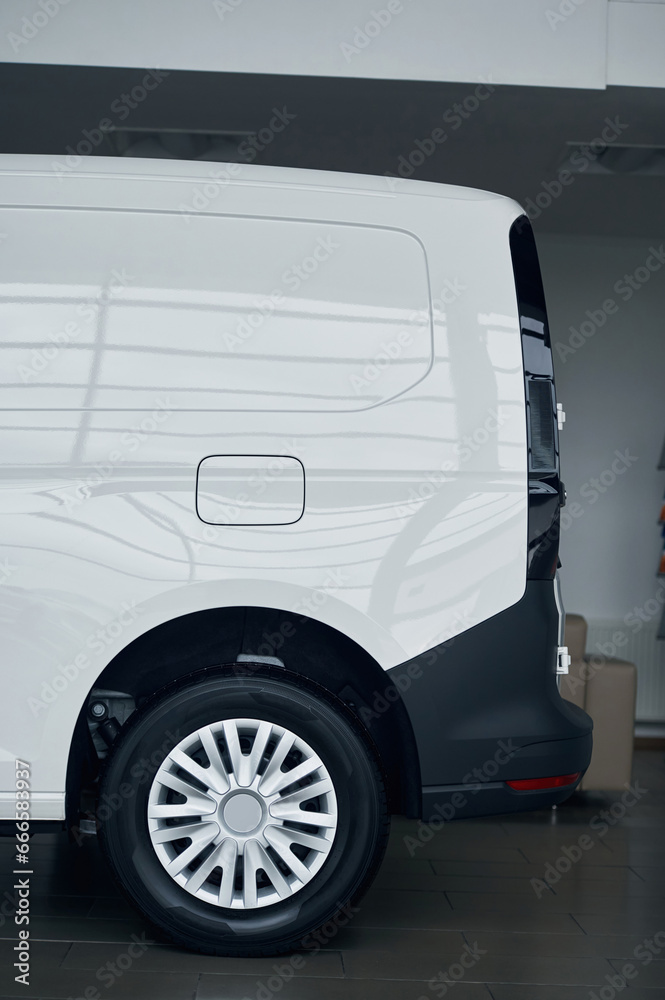 Side view of rear part of the white bus that is parked indoors Side view of rear part of the white bus that is parked indoors
