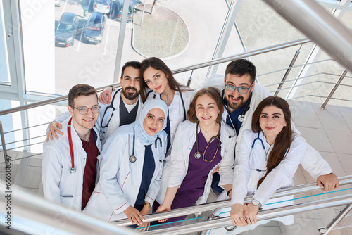 A group of happy smiling doctors in the hospital corridor. Medical students of different races in kapmus