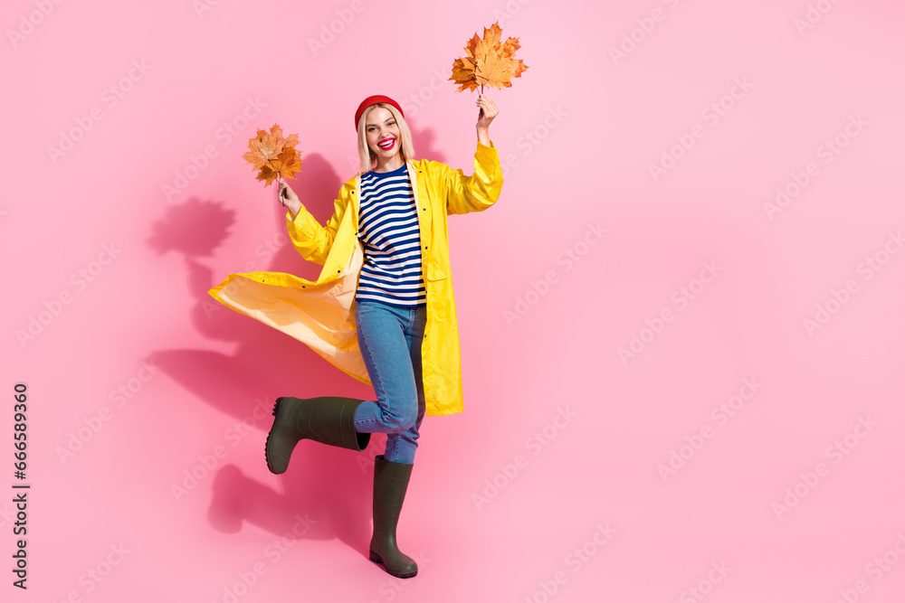 Photo of excited pretty woman dressed rain coat rising yellow leaves empty space isolated pink color background Photo of excited pretty woman dressed rain coat rising yellow leaves empty space isolated pink color background