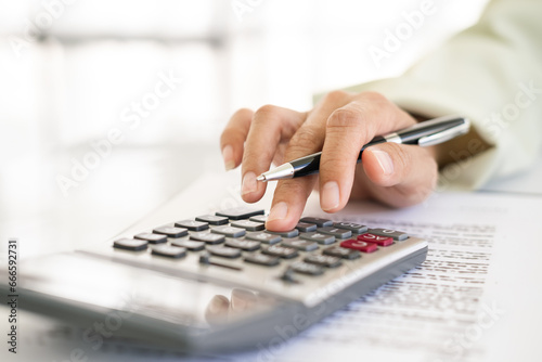 Hand of Business people calculating interest, taxes and profits to invest in real estate and home buying