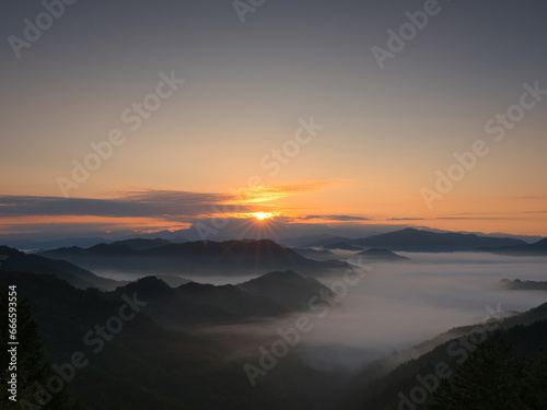 朝日が昇る雲海の山