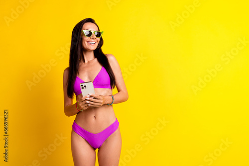 Photo of positive lady using cell smart phone looking browsing travel agency ads isolated vibrant color background