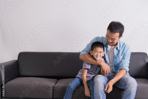 happy asian Father and son are sitting on the couch. Cute boy with dad playing at home. happy family, father day